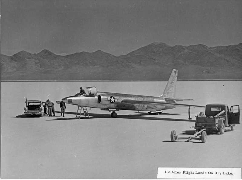 两名飞行员站在一辆汽车和一架 U-2 飞机旁边。